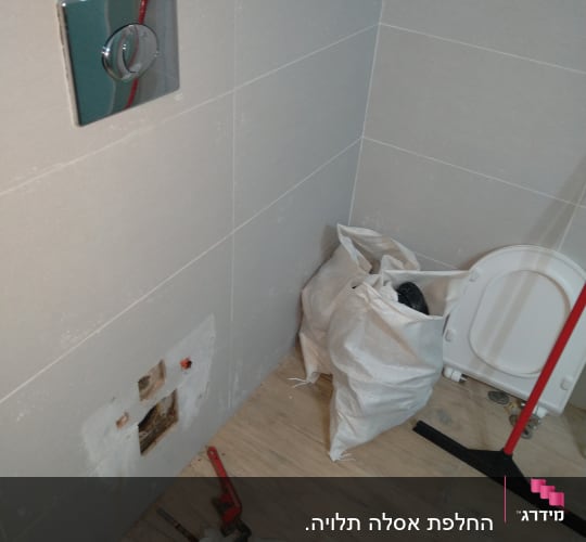 עבודת אינסטלציה עם כלים וחלקים בשירותים